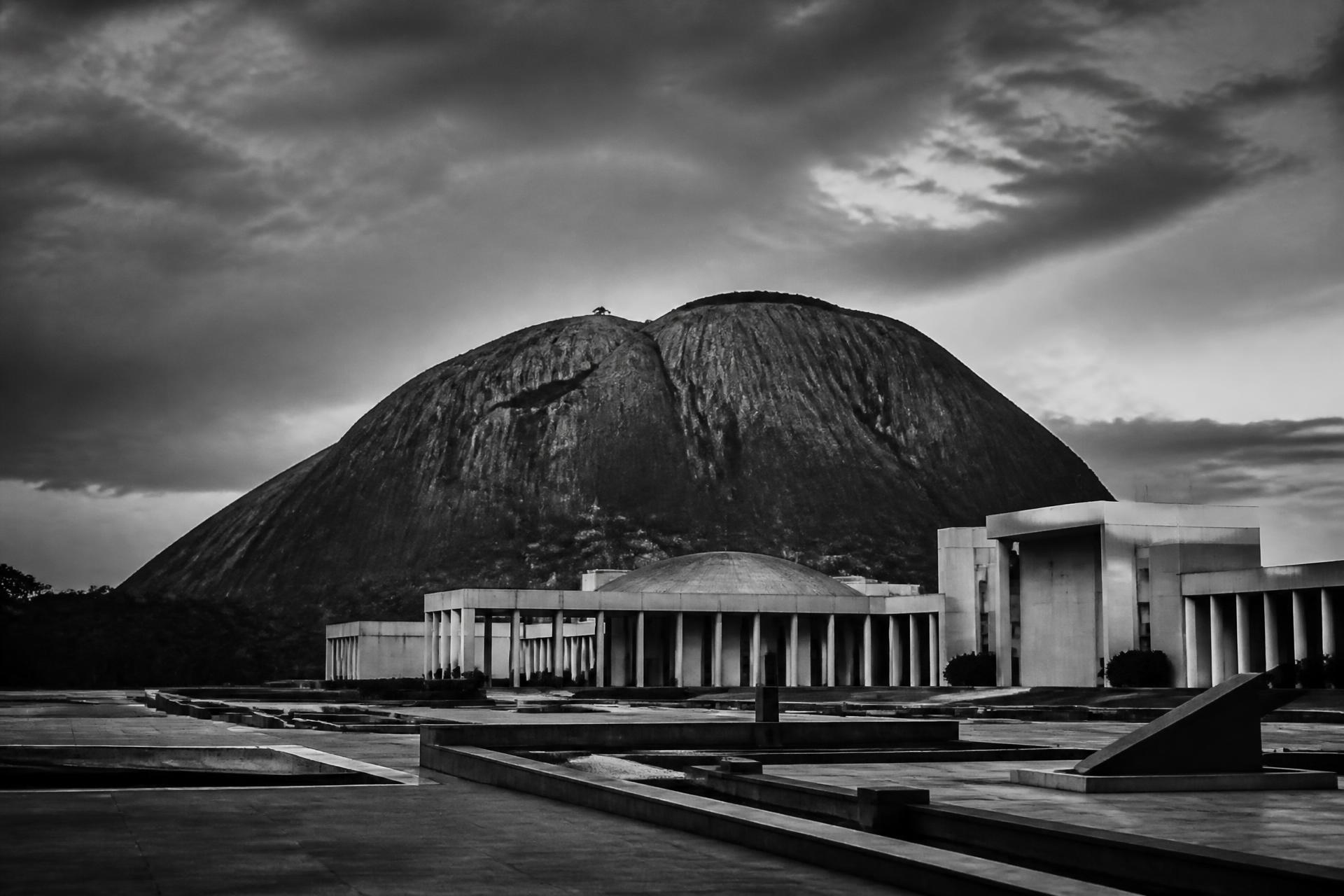 Monochrome view of Aso Rock rising behind the government precinct in Abuja at dusk